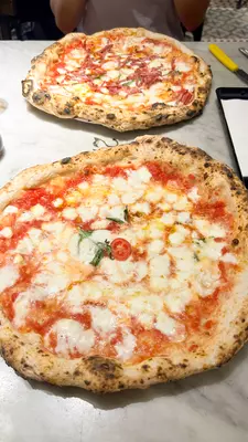 Two pizzas with tomato sauce and cheese.