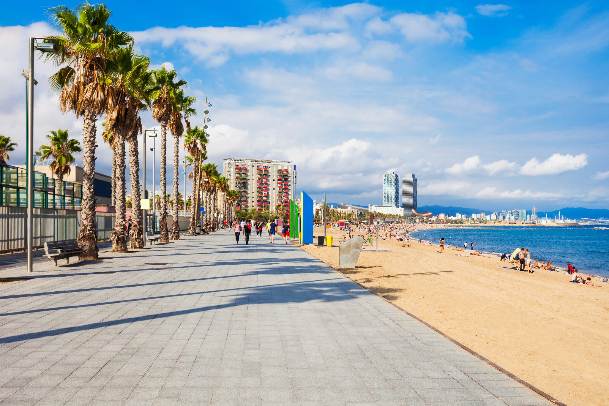 View over the walkway and beach at Platja de la Barceloneta in Barcelona, Spain.