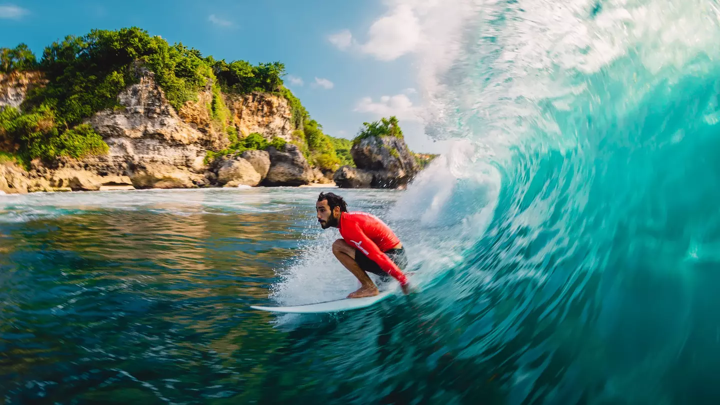 Surfer riding a barrel wave at Padang Padang on Bali, Indonesia.