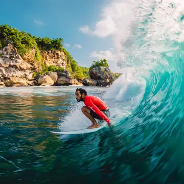 Surfer riding a barrel wave at Padang Padang on Bali, Indonesia.