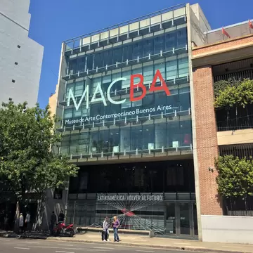 Front entrance of the Museum of Contemporary Art of Buenos Aires (MACBA). Two people standing under awning.