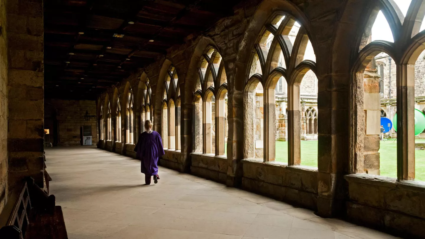 A person walks down a corridor in the cloisters of Durham Cathedral, Durham, England, United Kingdom