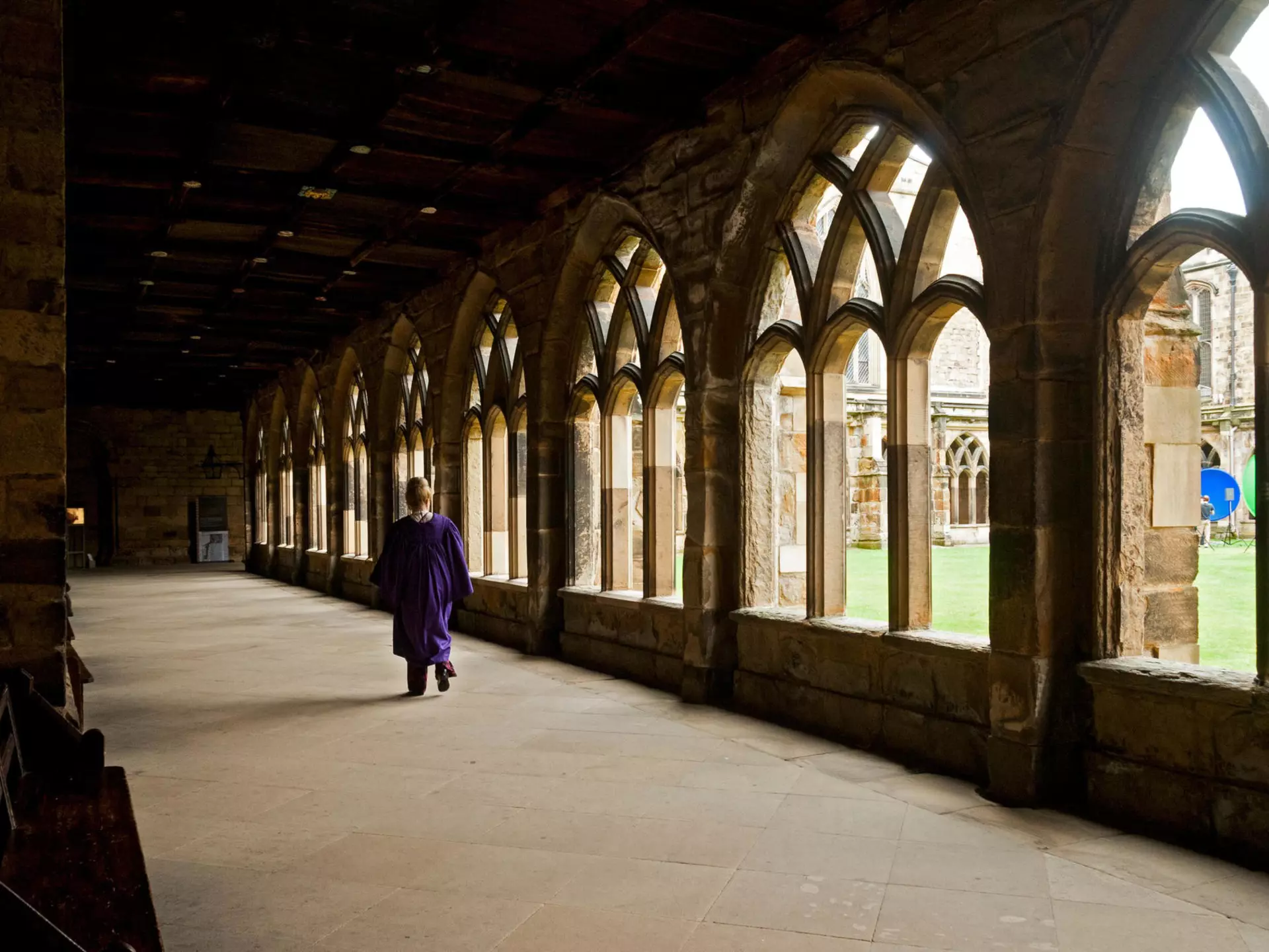 A person walks down a corridor in the cloisters of Durham Cathedral, Durham, England, United Kingdom