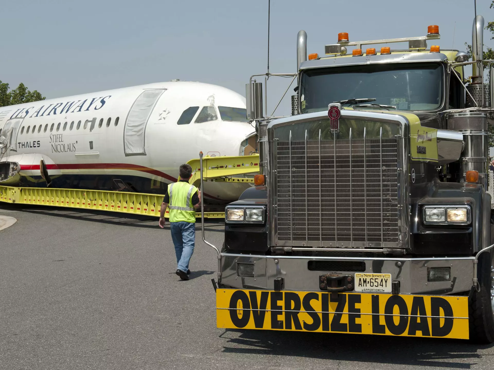 A plane on a massive truck as it is moved to a museum.