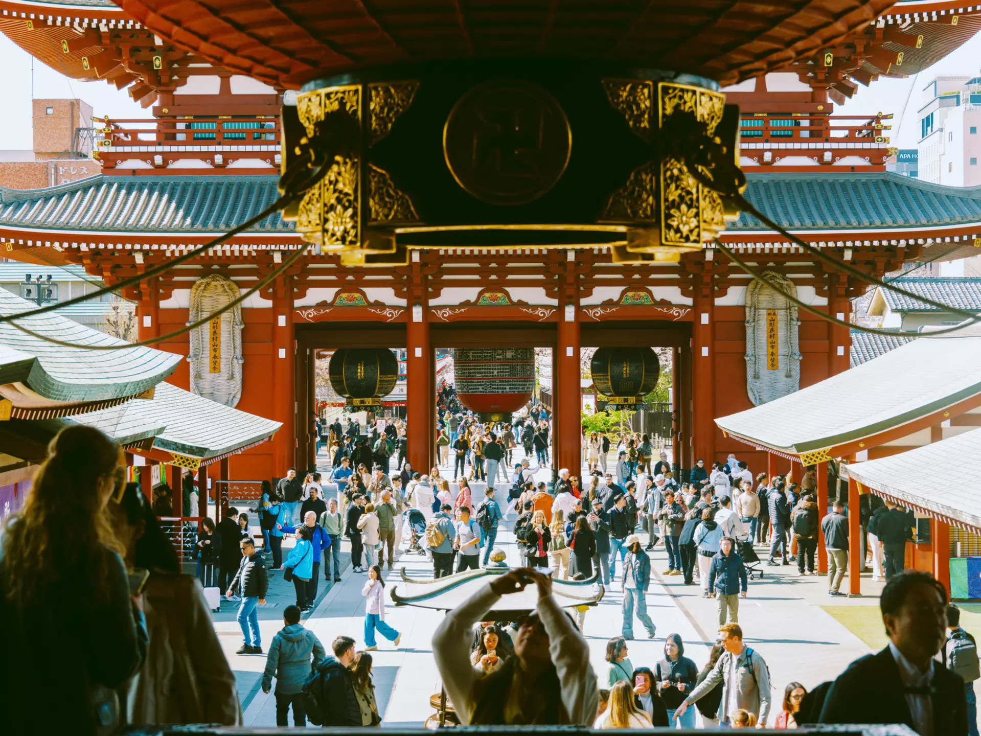Crowds of people are pictured in the pagoda-covered pavilion of a temple.