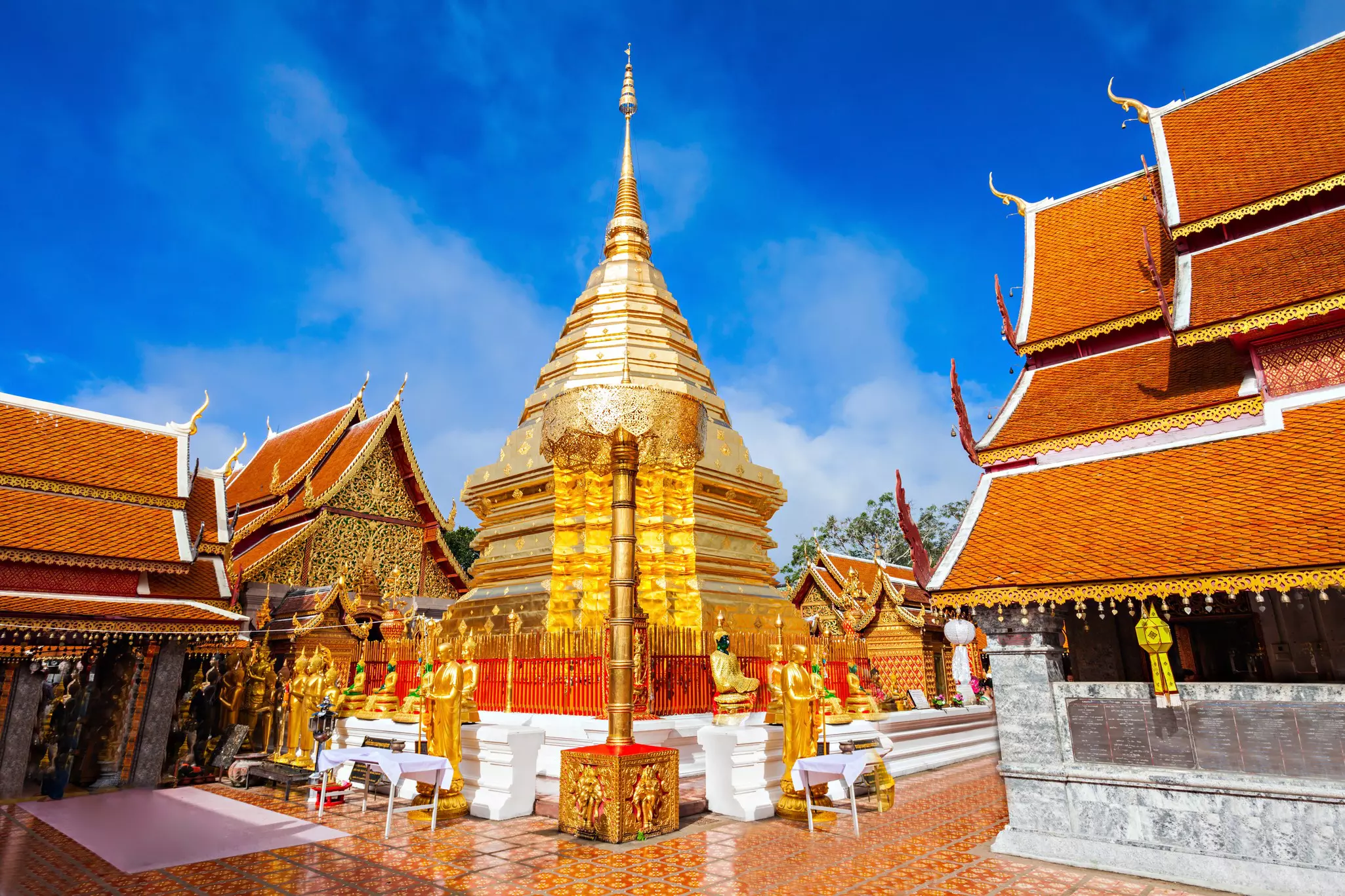Wat Phra That Doi Suthep, a golden temple with golden statues along the perimeter of the gate