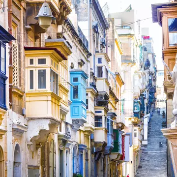 Typical narrow streets with colorful balconies in Valletta, Malta.