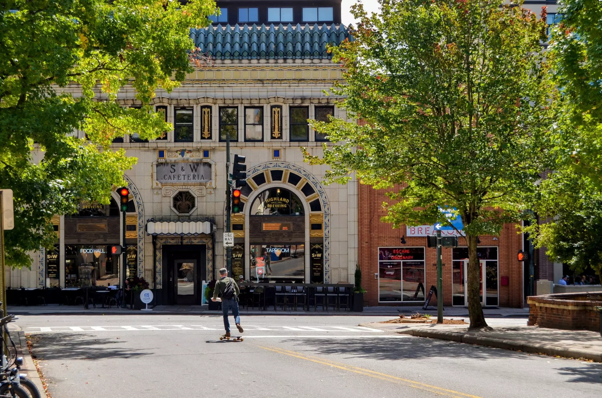 A skateboarder crosses the street in front of the historic SandW Cafeteria building in downtown Asheville.,