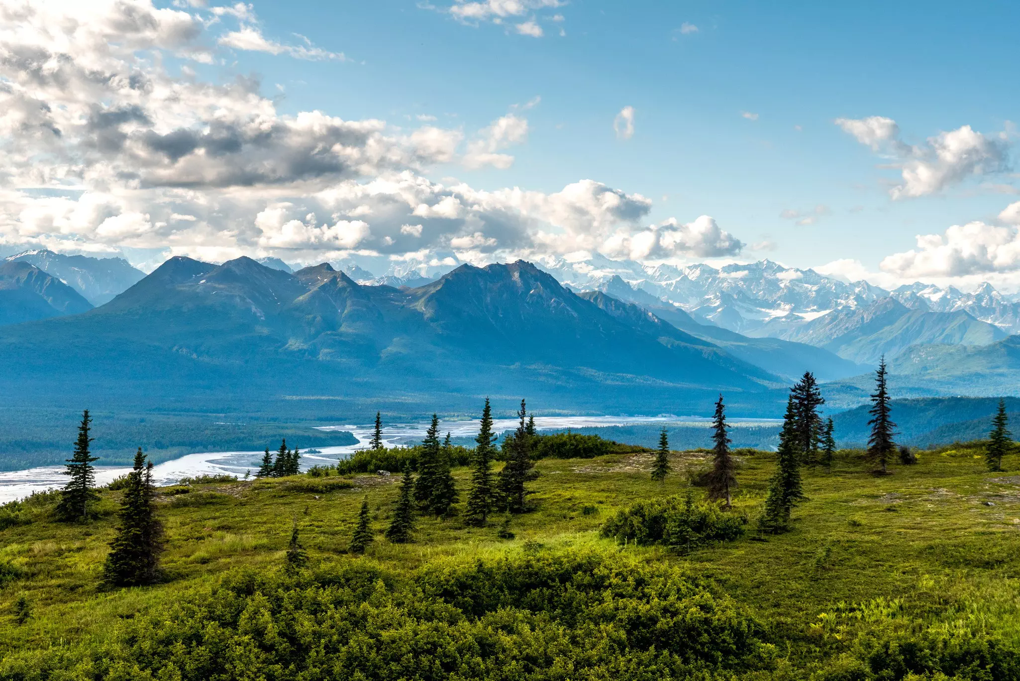 A mountainous landscape viewed from a hiking trail.