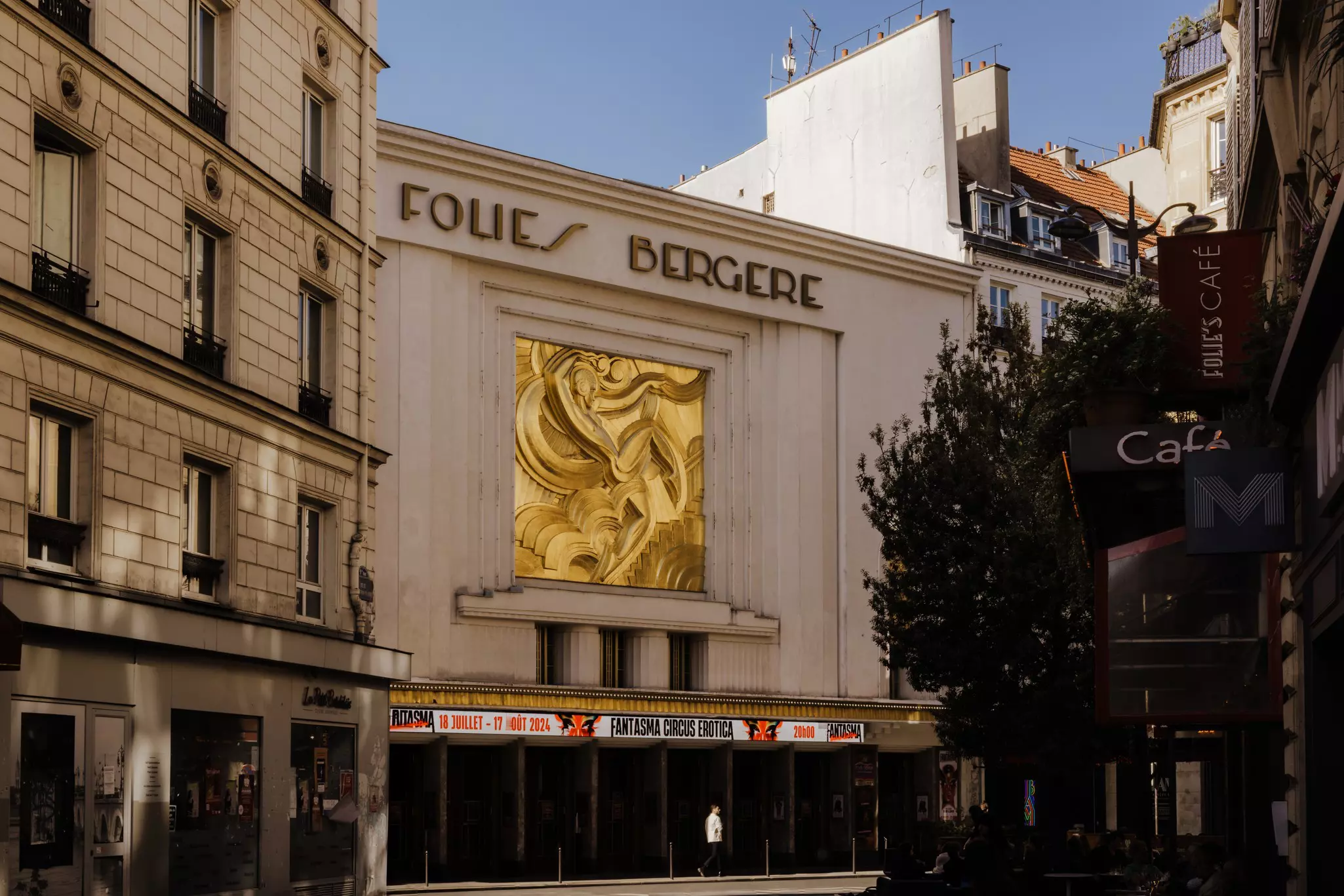 Exterior of a theater with an ornate gold art deco feature on its facade.