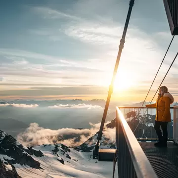woman watches the sunset /sunrise at Mont Fort Valais Switzerland with snow mountain landscape; Shutterstock ID 1777362002;