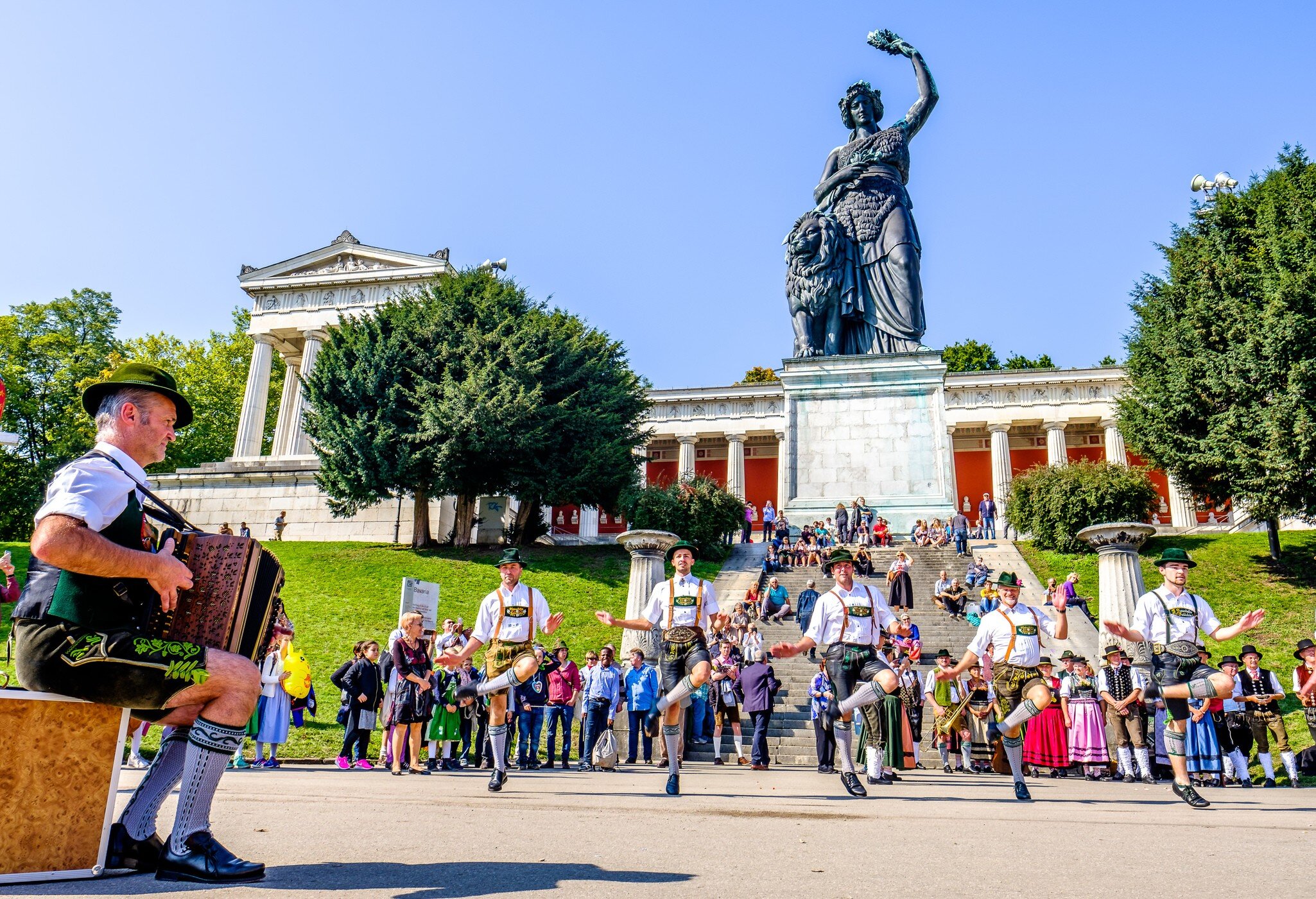 Traditional dancing group in front of the Bavaria Statue at the Octoberfest in Munich.