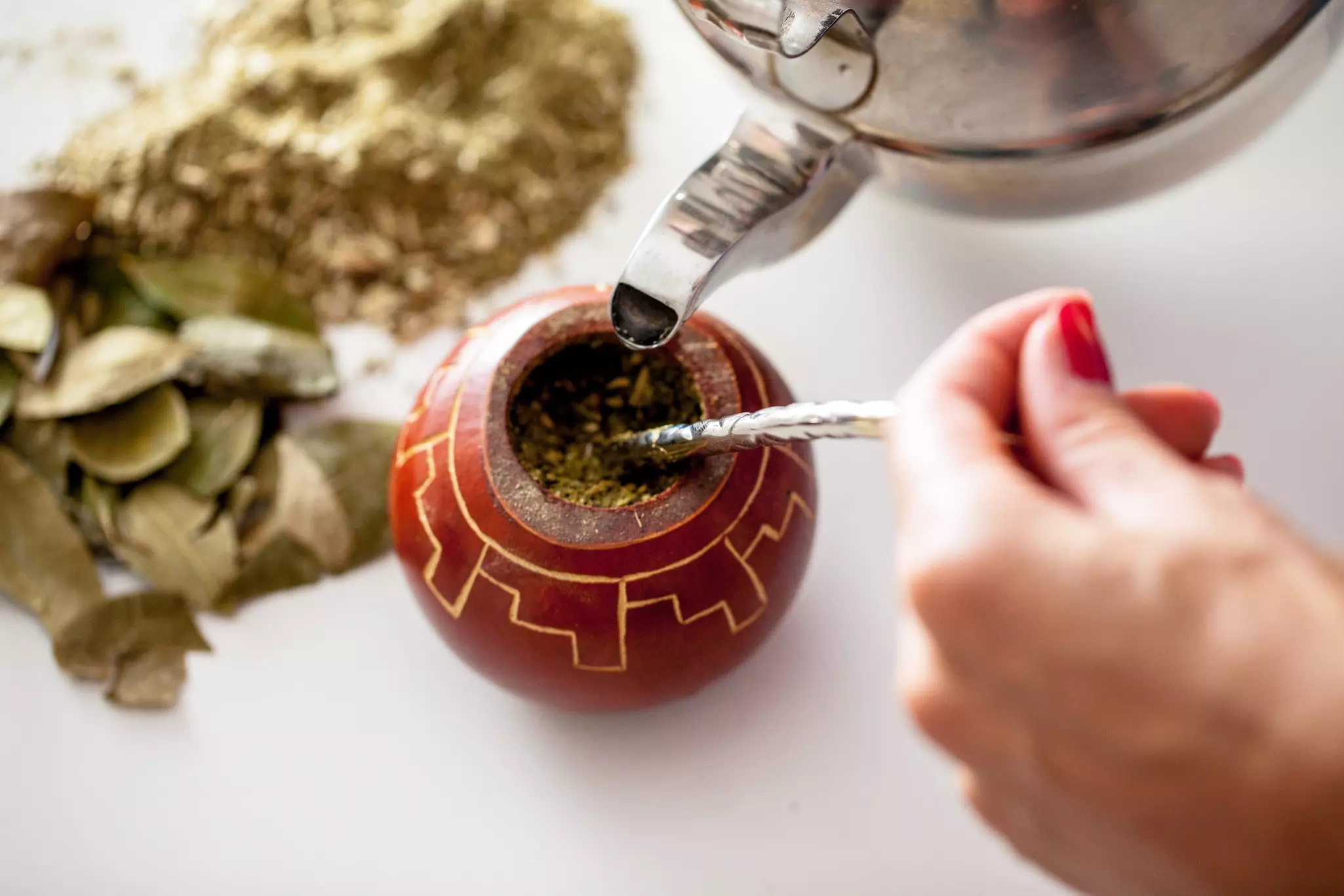 In South America, mate tea is made by filling a hollow gourd with dried yerba mate leaves and hot water and drank through a metal straw (bombilla) ©Getty Images/iStockphoto