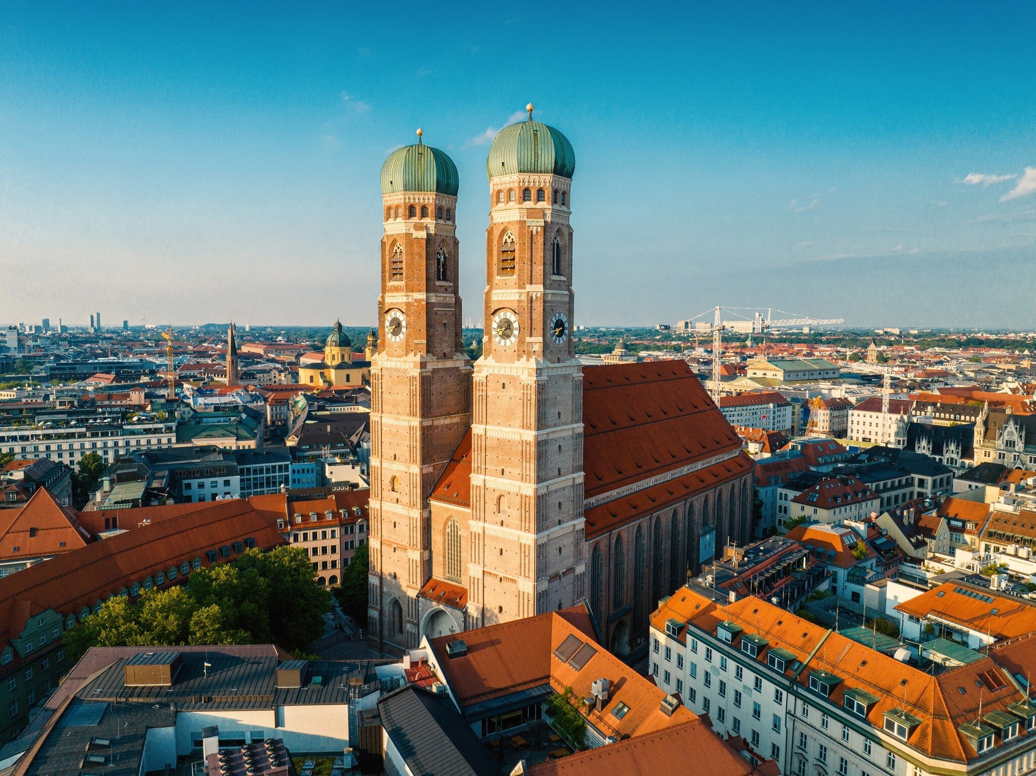 The twin domes of the Frauenkirche stand sentinel over Marienplatz in Munich, Germany on a summer evening.