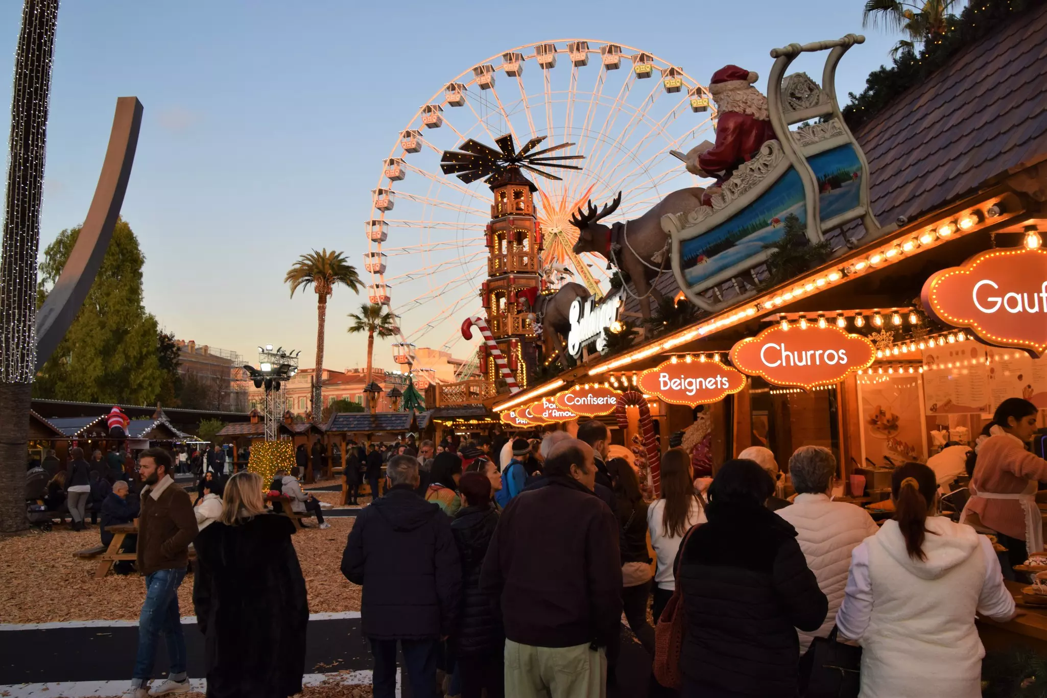 People and stalls at the Christmas market Place Massena.
