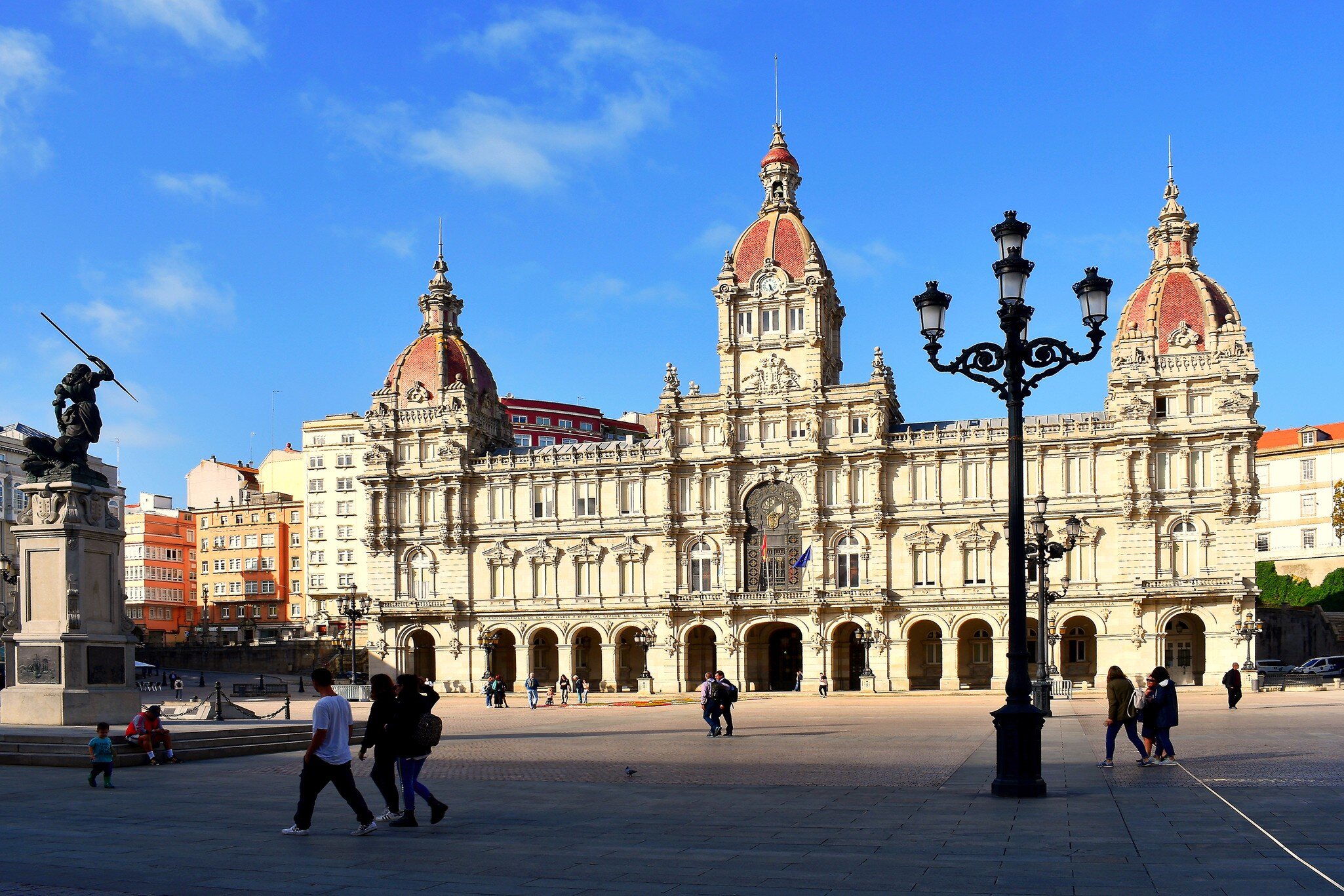 View of people passing by the City Hall on the Plaza de María Pita in A Coruña, Spain.