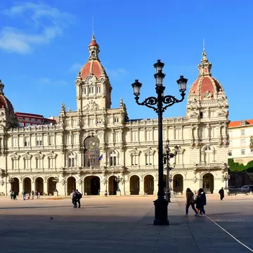 View of people passing by the City Hall on the Plaza de María Pita in A Coruña, Spain.