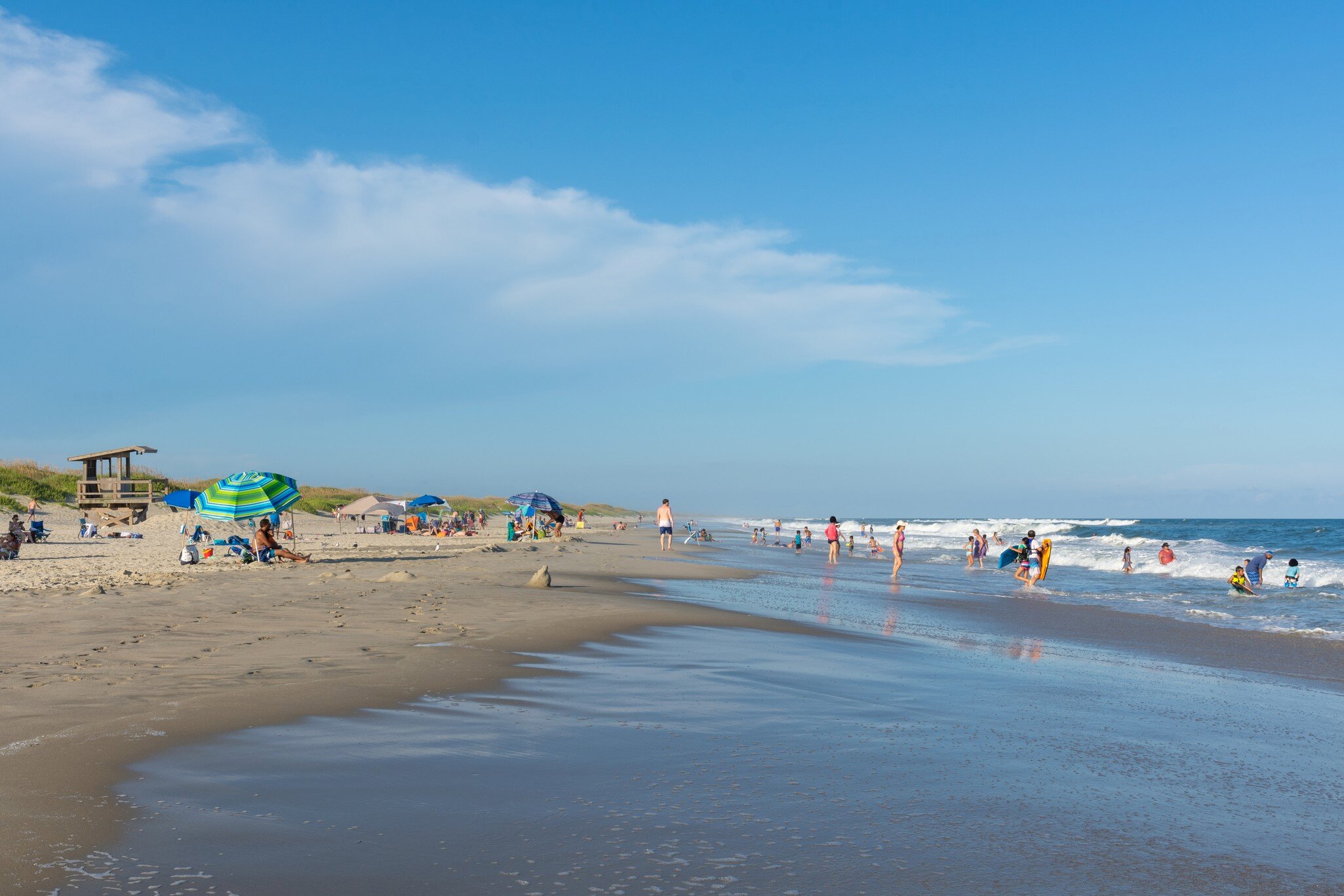 Ocracoke, North Carolina, August 19, 2021 - People relax on the beach and swim in the surf of the lifeguarded beach on Ocracoke Island, part of the Cape Hatteras National Seashore.