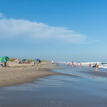Ocracoke, North Carolina, August 19, 2021 - People relax on the beach and swim in the surf of the lifeguarded beach on Ocracoke Island, part of the Cape Hatteras National Seashore.