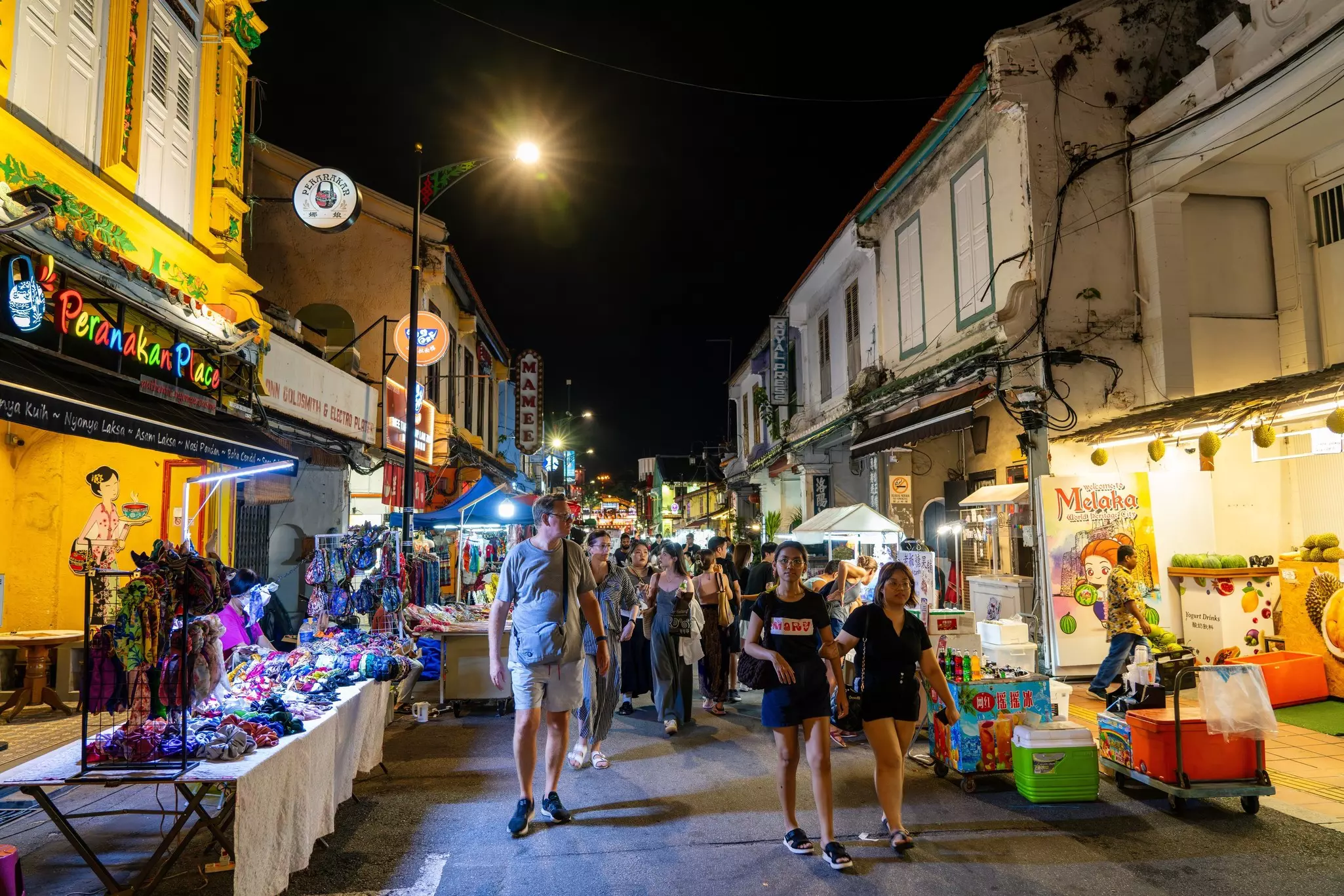 People walking in a crowded street market at night