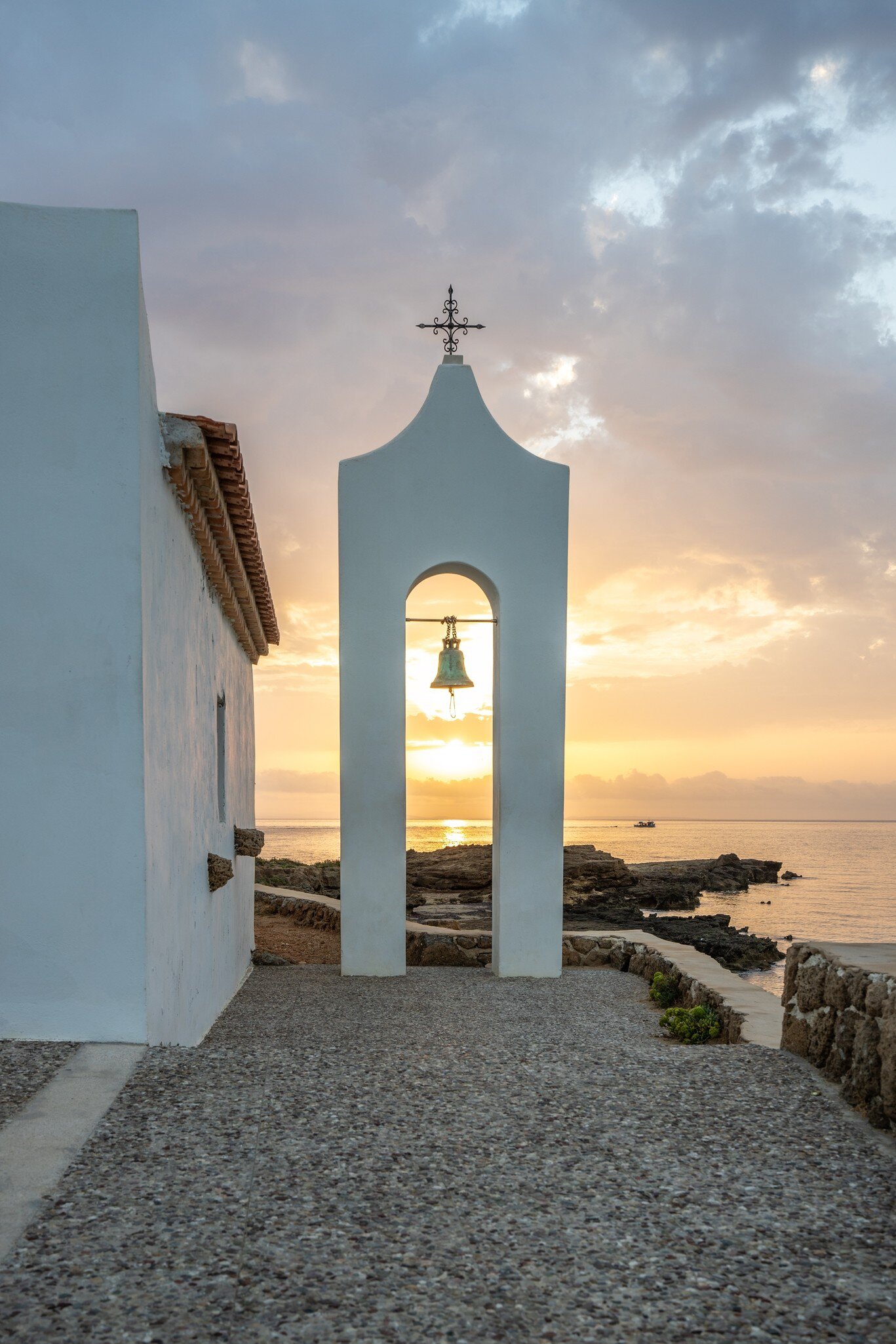 Small white church in the typical architectural style of Greece. She stands on a tree surrounded by the Mediterranean and in the sunrise.Chapel of Agios Nikolaos, Ionian Islands, Greece, License Type: media, Download Time: 2025-07-10T17:27:39.000Z, User: katelyn.perry_lonelyplanet, Editorial: false, purchase_order: 65050 - Digital Destinations and Articles, job: WIP, client: APP, other: Katelyn Perry