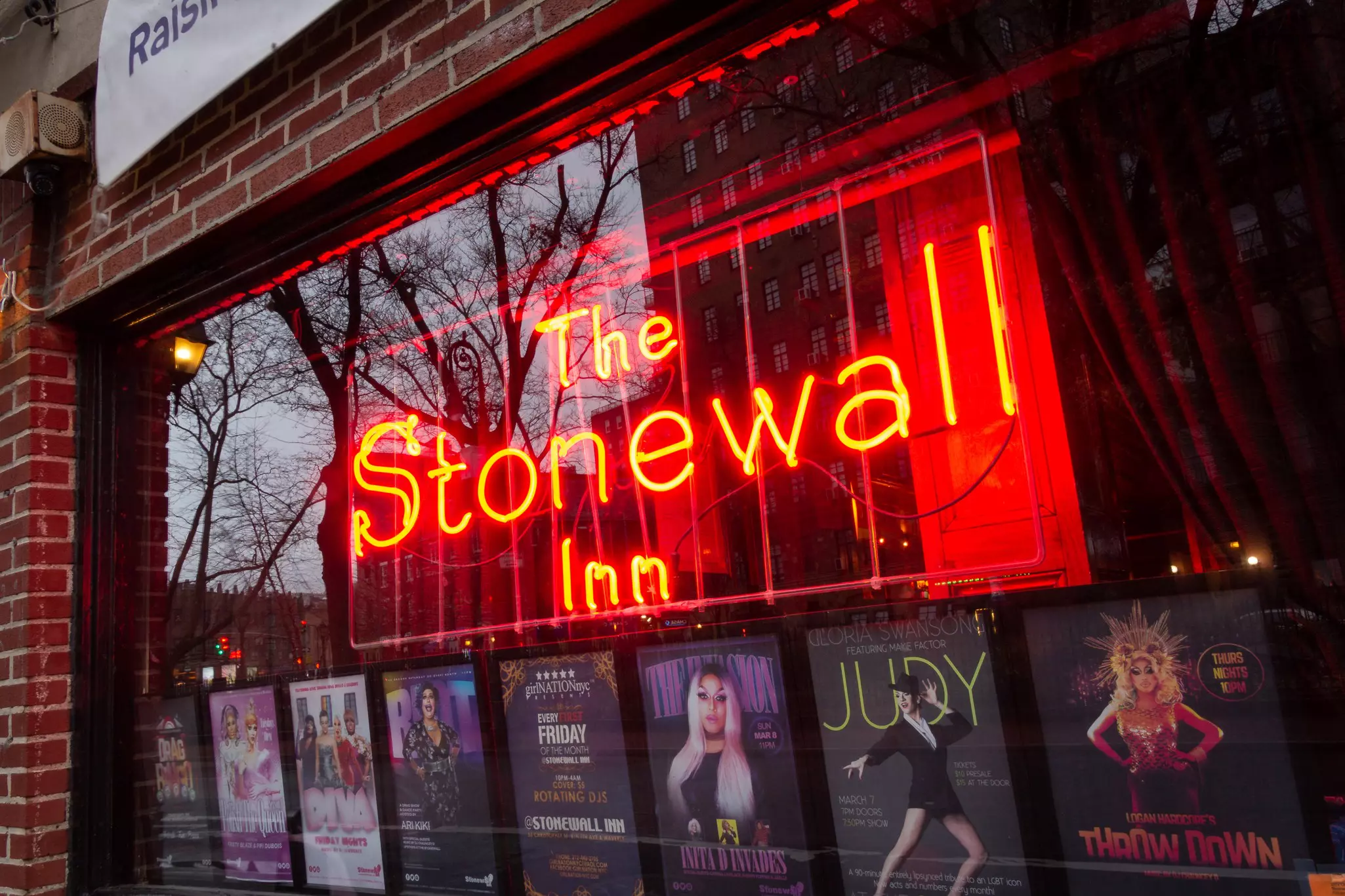 Closeup on the window and sign of The Stonewall Inn