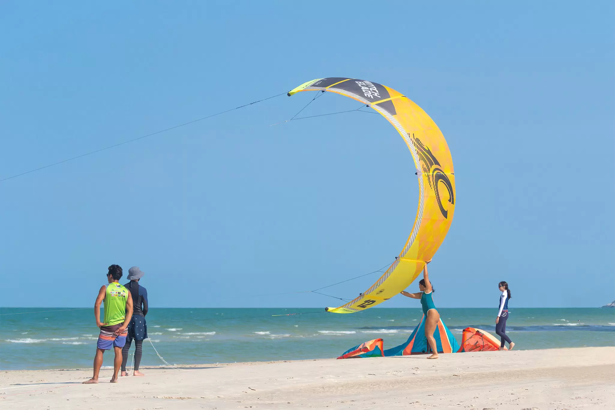 View of people kitesurfing on a sunny day at Hat Hua Hin in Thailand.