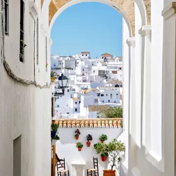 View down an alleyway of the whitewashed buildings of Vejer de la Frontera, Spain.