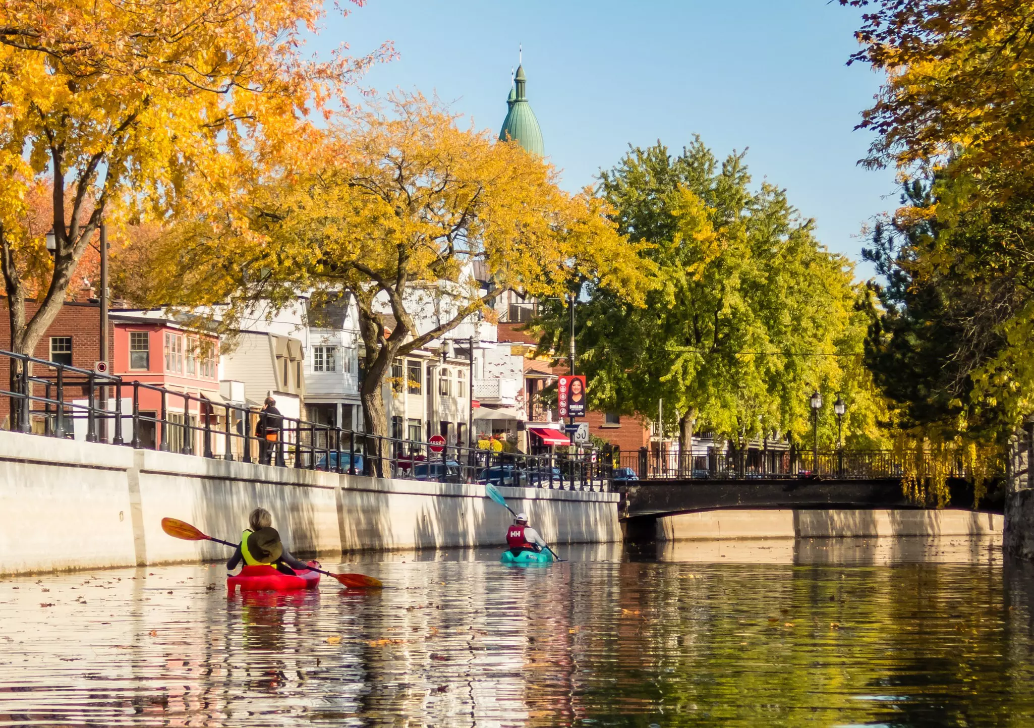 Kayakers paddle down the Lachine Canal in the fall.