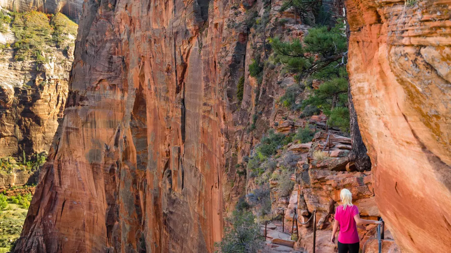 A woman hikes along a high path in Utah.