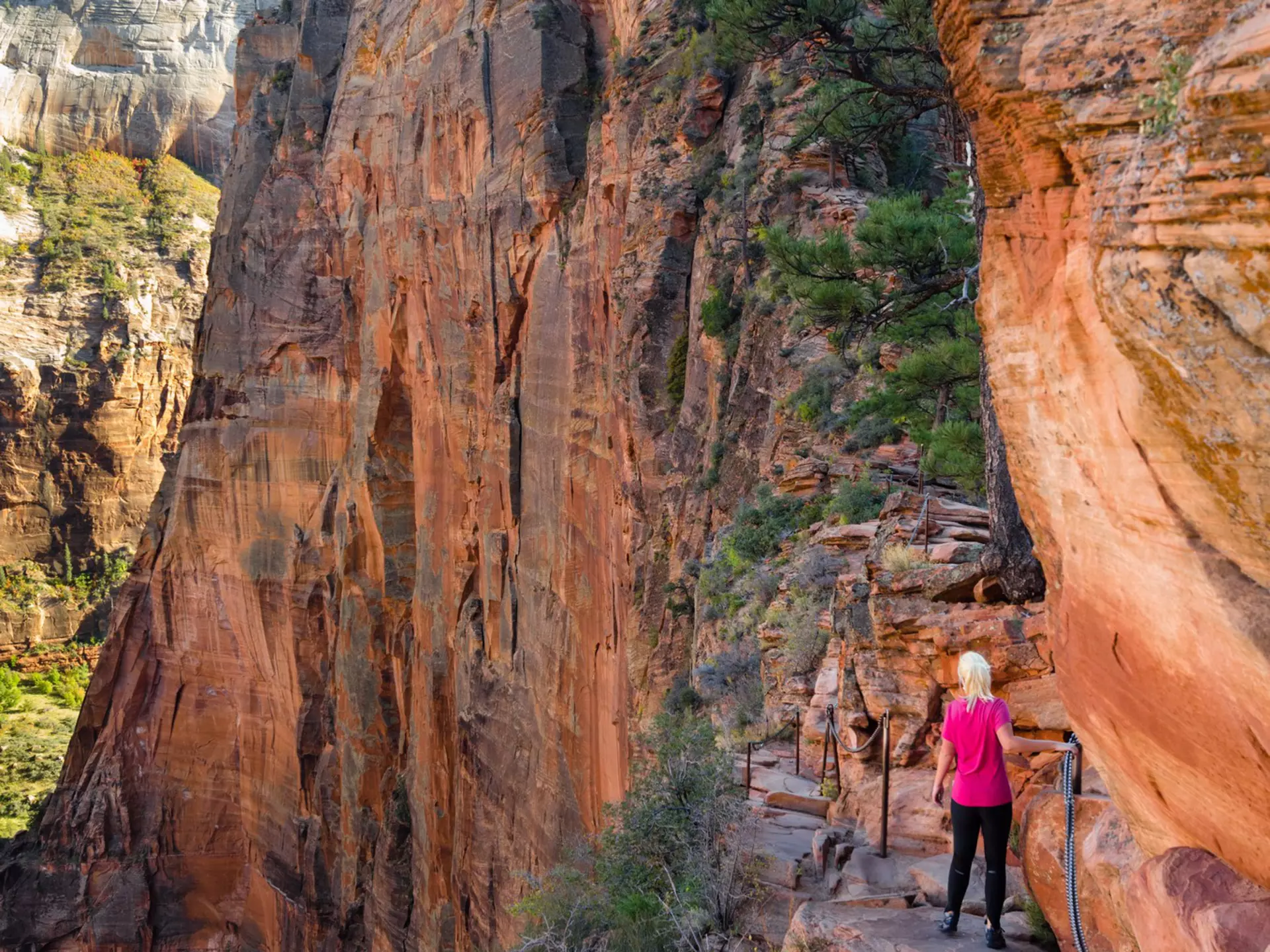A woman hikes along a high path in Utah.