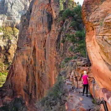 A woman hikes along a high path in Utah.