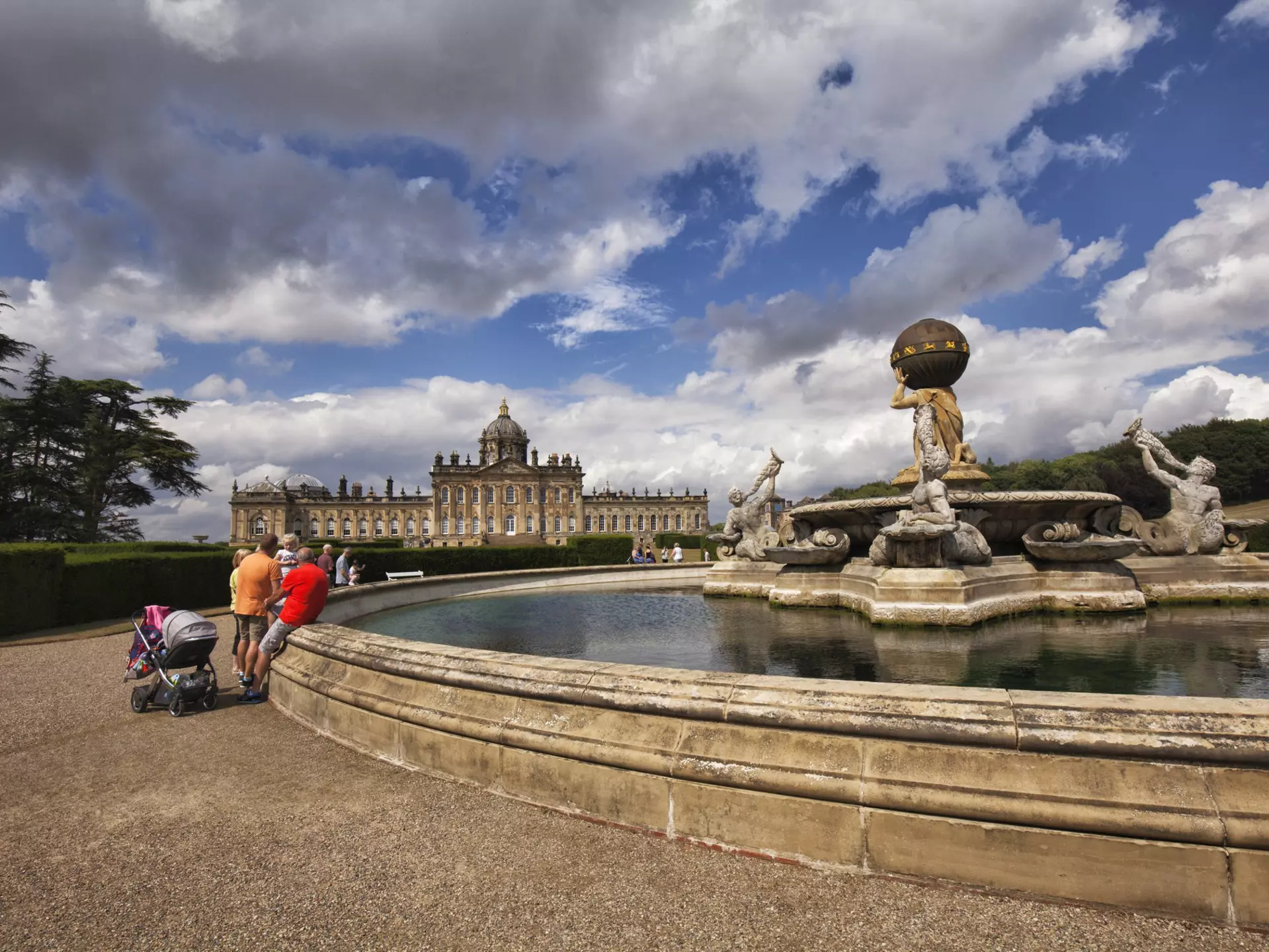 Tourists seen around the fountain in front of Castle Howard on a sunny afternoon, North Yorkshire