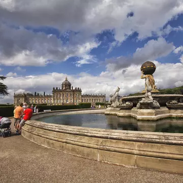 Tourists seen around the fountain in front of Castle Howard on a sunny afternoon, North Yorkshire