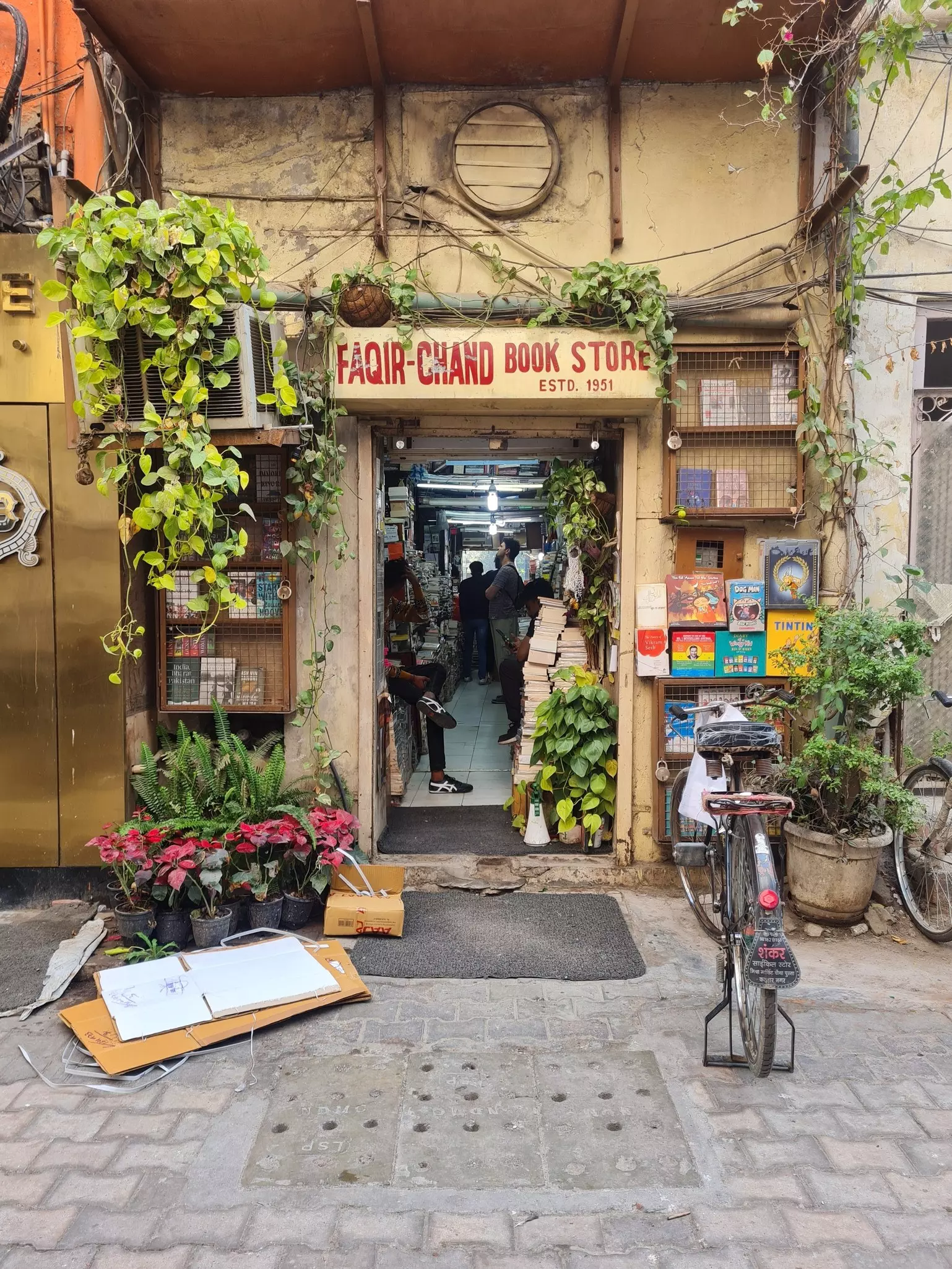 The entrance to a bookstore dotted with plants and books