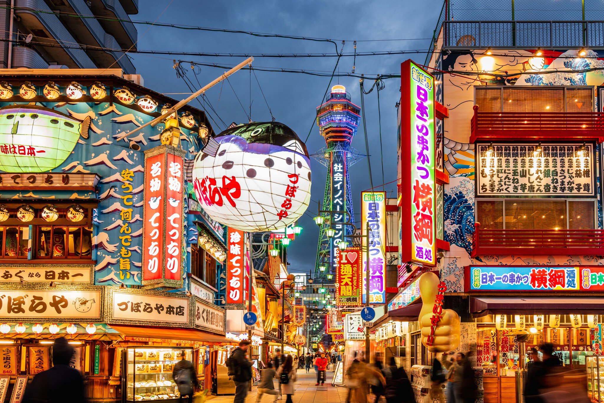 Crowded Shinsekai District, Tsutenkaku Tower in the background. Illuminated Neon Billboards at Night, Vibrant Osaka Shinsekai Cityscape. Shinsekai, Osaka, Japan, Asia