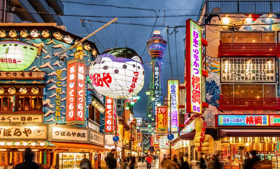 The crowded Shinsekai district with Tsutenkaku Tower in Osaka, Japan