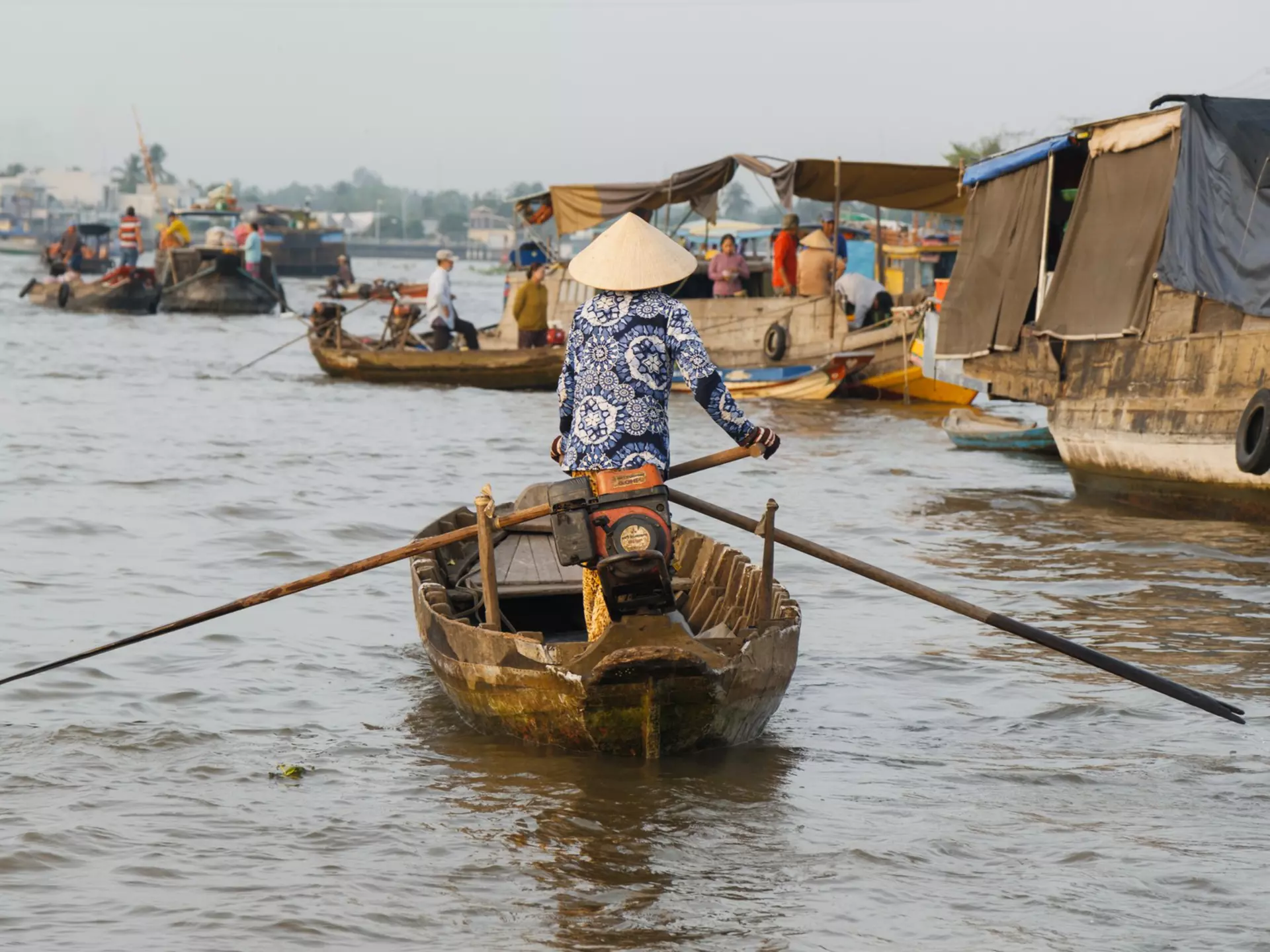 Small wooden rowing boats being piloted along the Hau River at Can Tho, Vietnam. 