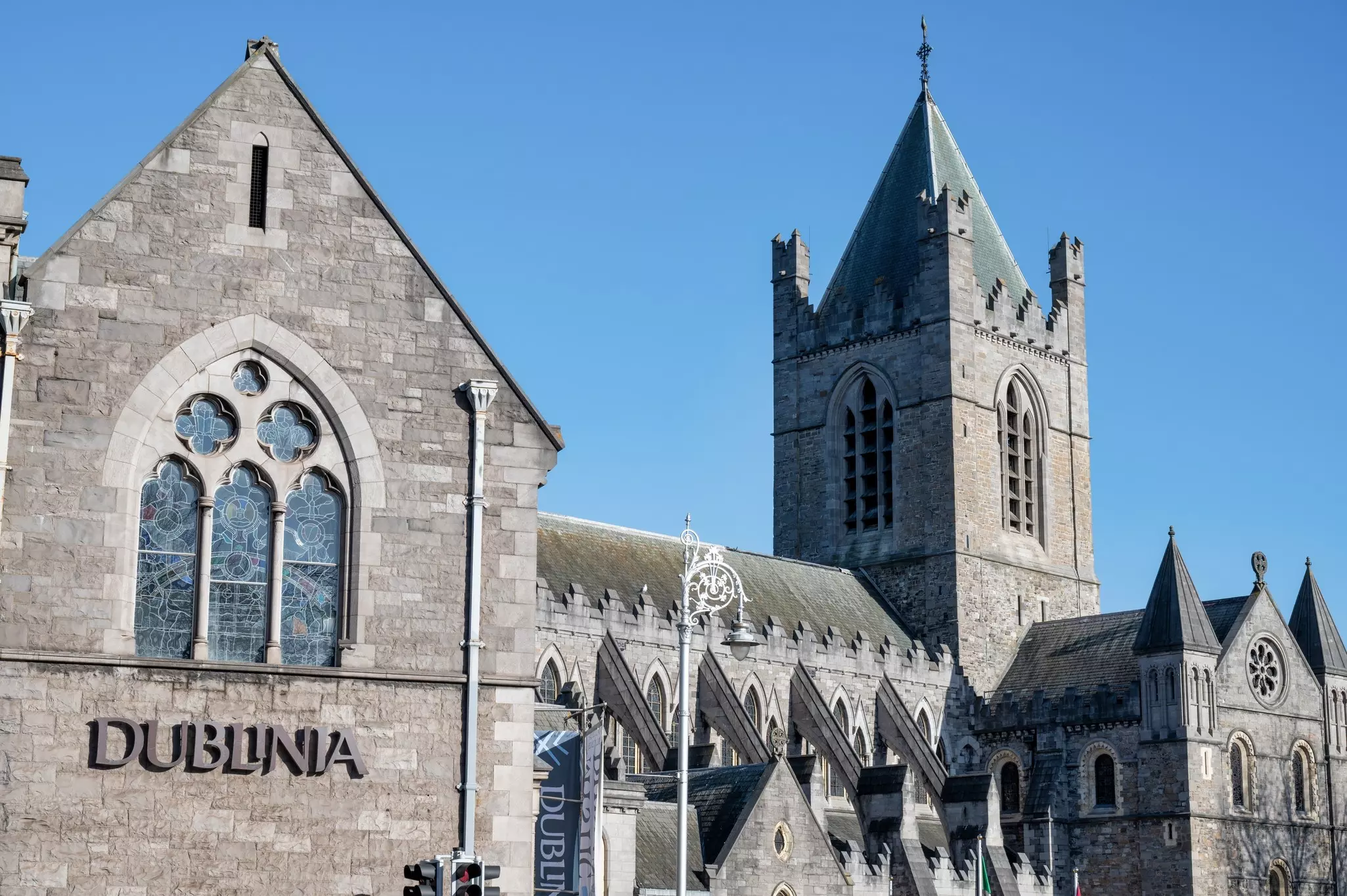 A large stone building with a sign that reads "Dublinia" next to a medieval tower. 