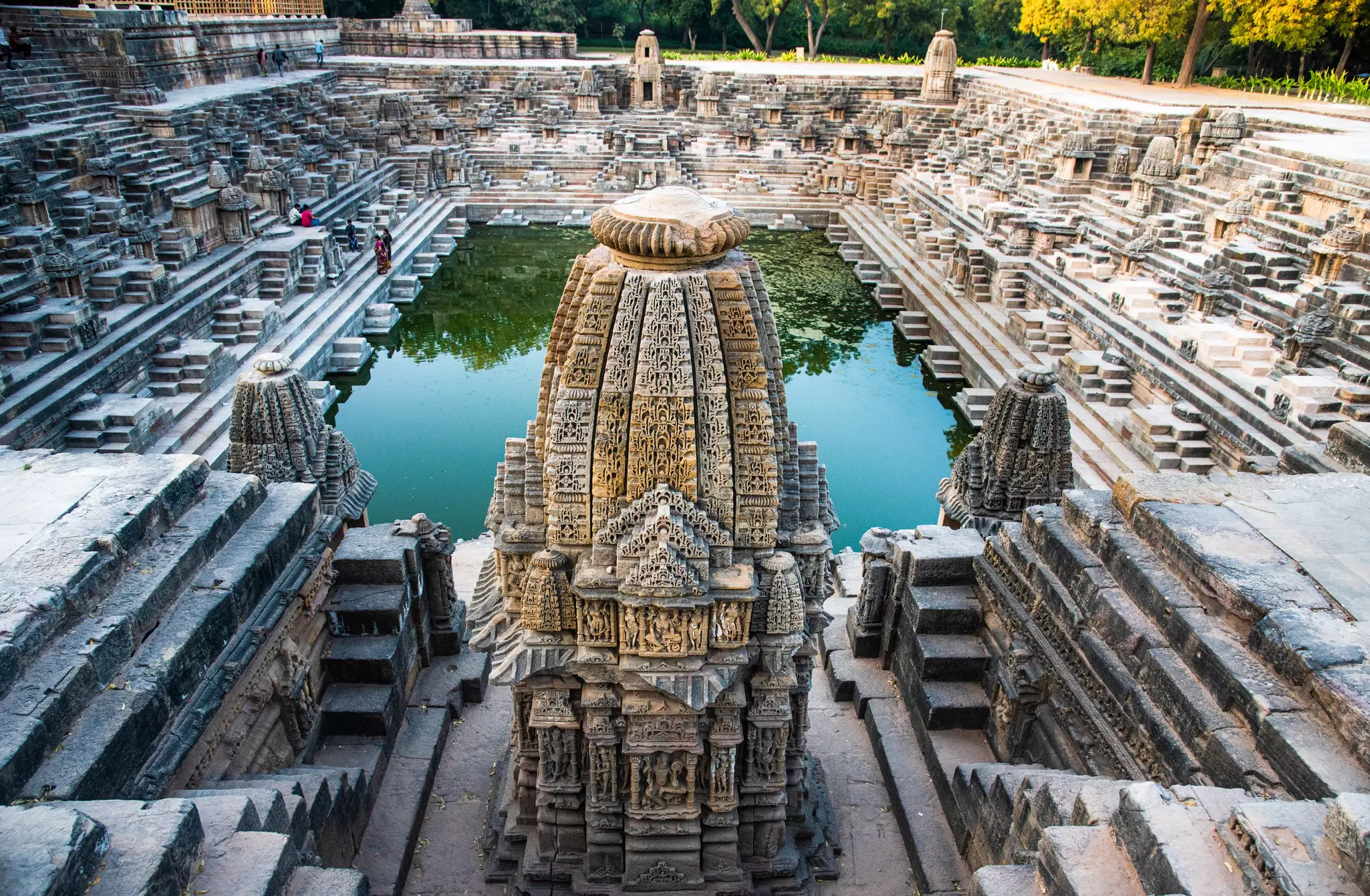A large rectangular body of water is surrounded by a complex of steps and carved turrets