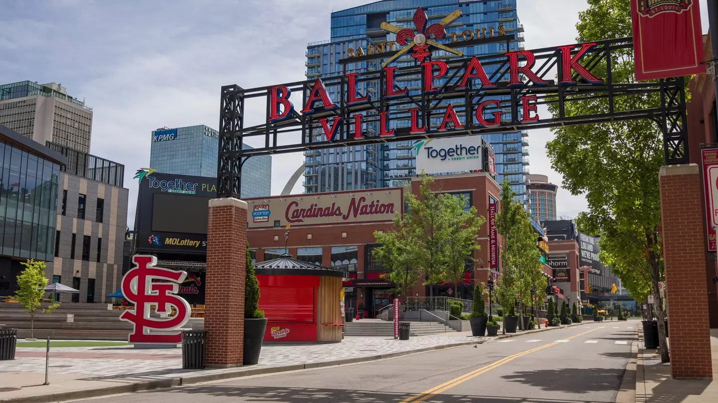 The entrance to a neighborhood with a large sign that says "Saint Louis Ballpark Village"
