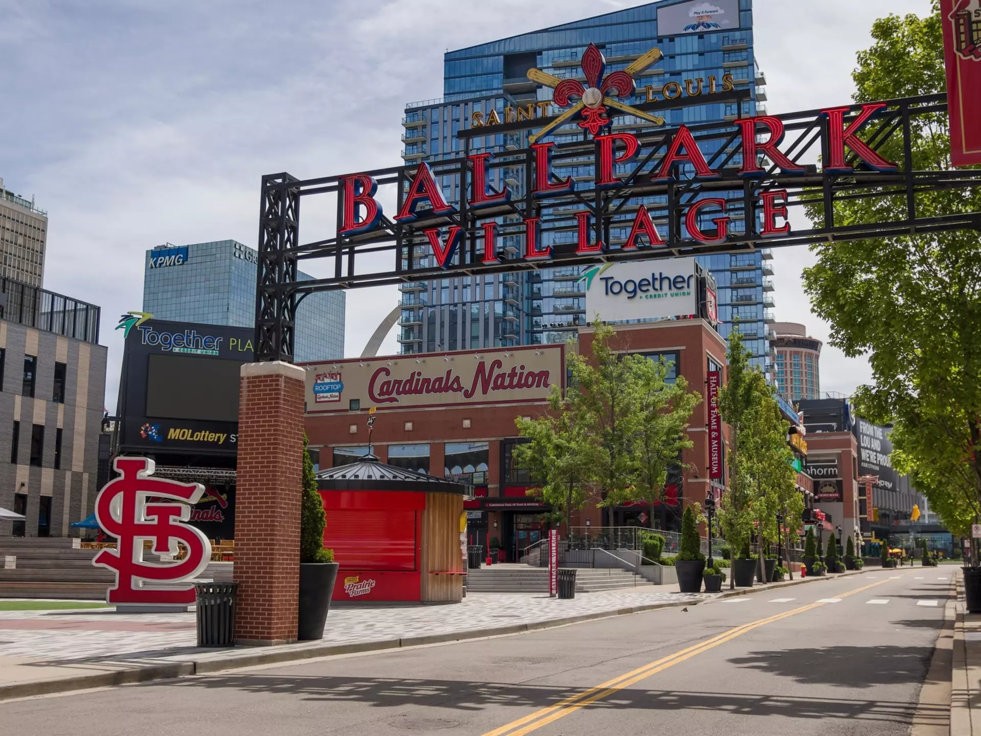 The entrance to a neighborhood with a large sign that says "Saint Louis Ballpark Village"
