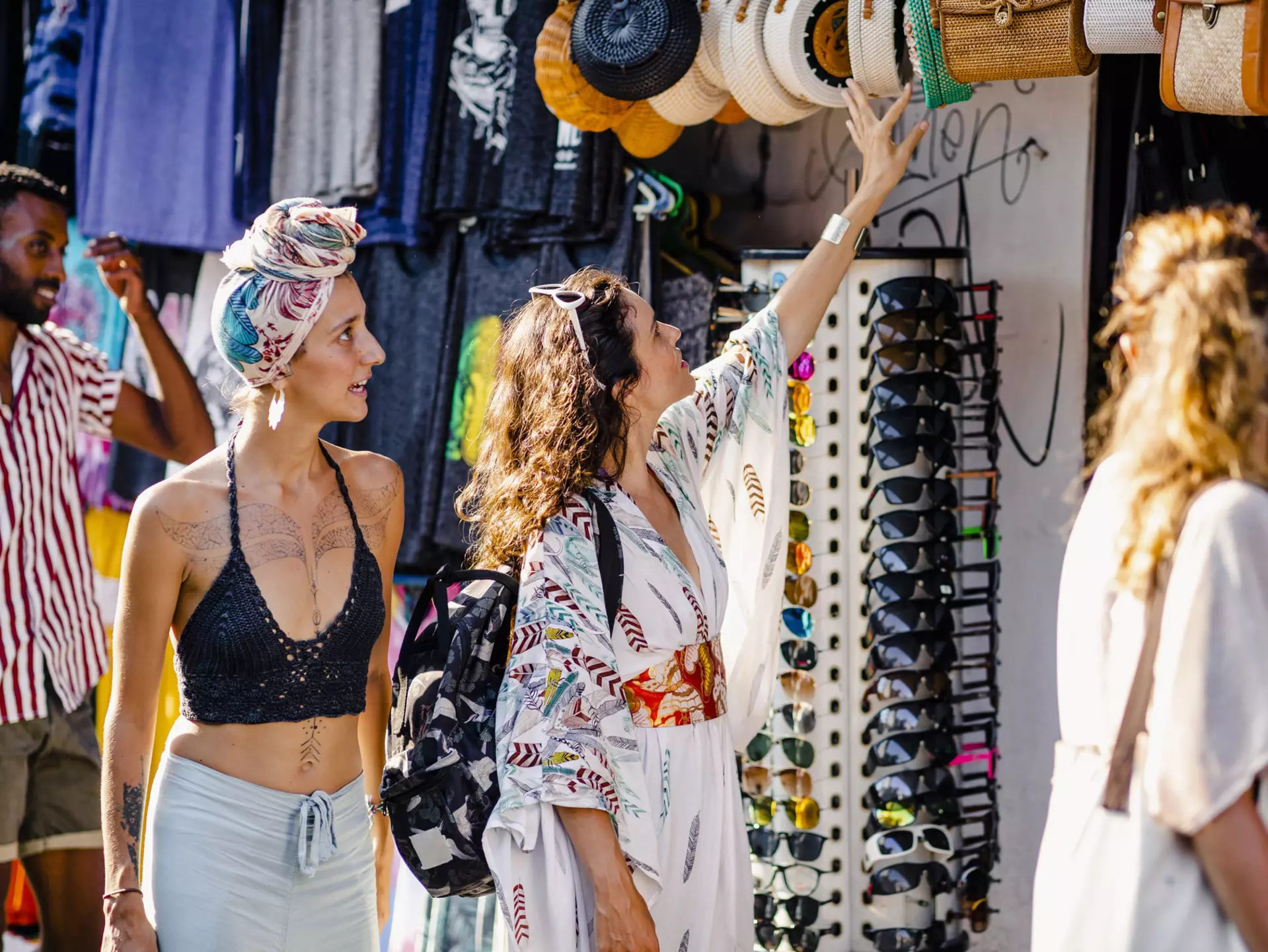 A group of friends browsing merchandise at market stalls while exploring in Bali, Indonesia