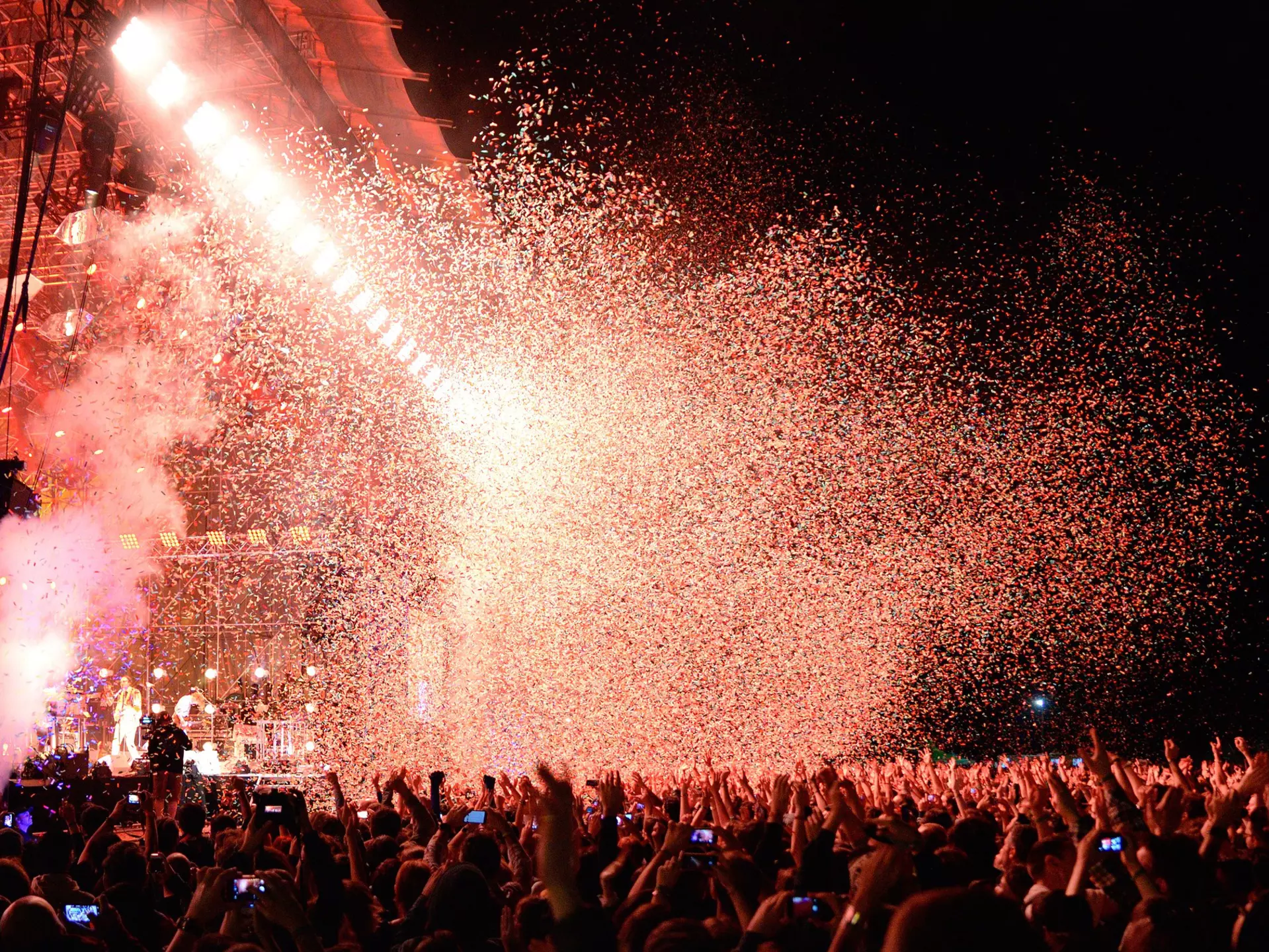 BARCELONA - MAY 29: Crowd watch a concert by the famous band Arcade Fire, while throwing confetti from the stage at Heineken Primavera Sound 2014 Festival on May 29, 2014 in Barcelona, Spain.  License Type: media  Download Time: 2023-07-19T11:09:17.000Z  User: ceri_lp  Is Editorial: Yes  purchase_order:   