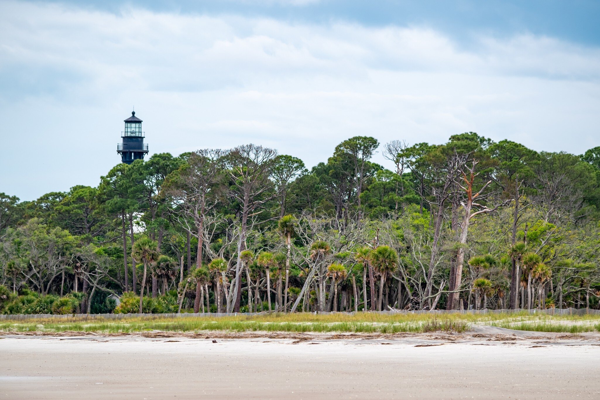 Hunting Island, South Carolina  United States - April 19, 2022: Moody cloudy sky over beach and lighthouse,  Hunting Island State Park; Shutterstock ID 2174327595;