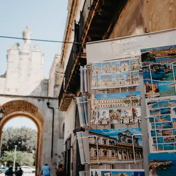 Porta San Biagio one of the gates of the old town with postcards on display for sale on the right