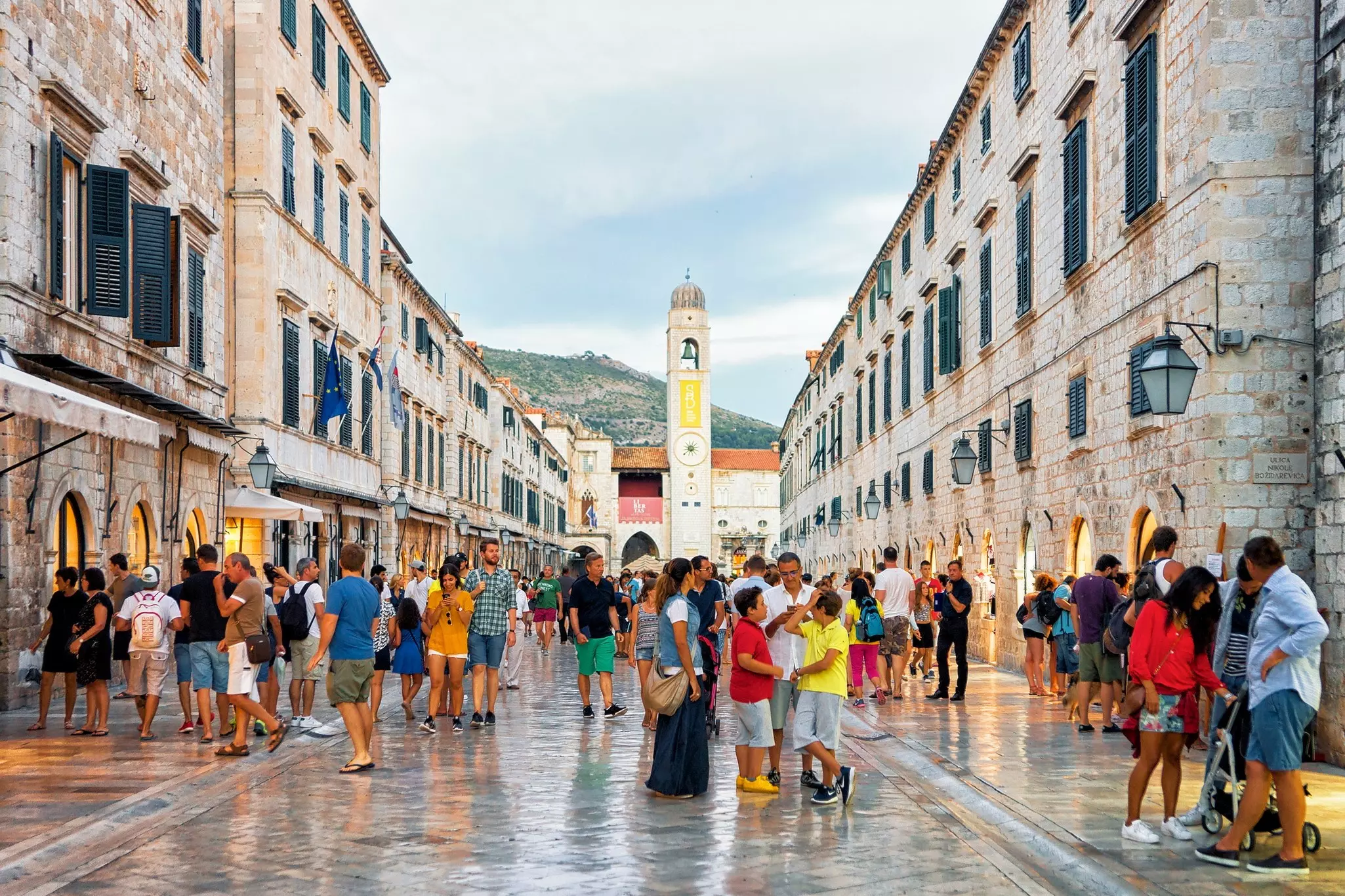 Tourists walking and standing along the Stradun in the old town of Dubrovnik.