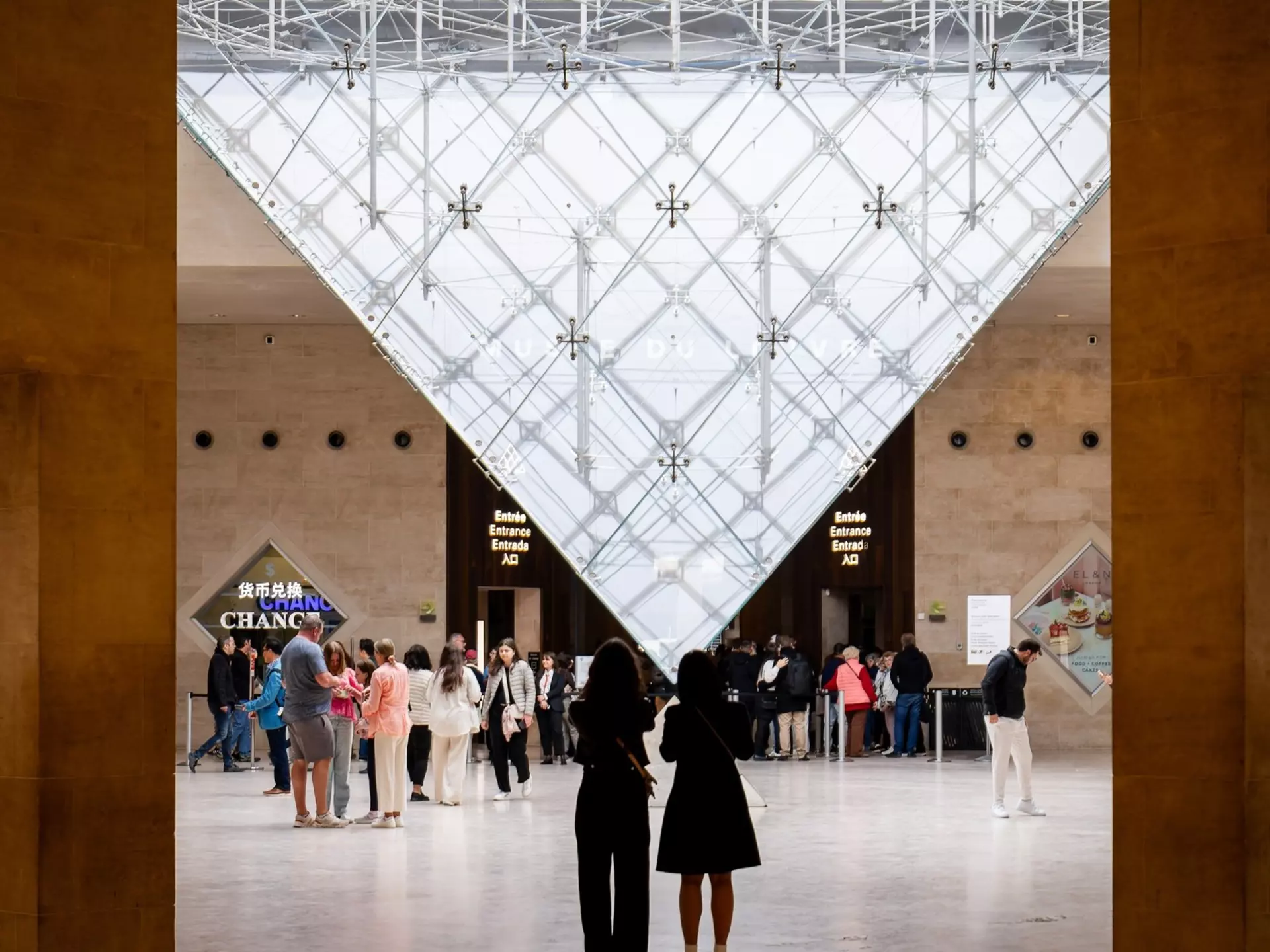 People standing in front of the Inverted Pyramid (Pyramide Inversée) located in the Carrousel du Louvre shopping mall in front of the Louvre Museum.