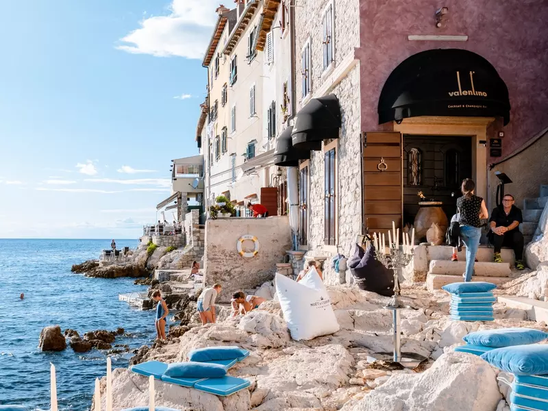 People watching the sunset from a restaurant at ocean front Rovinj village. 