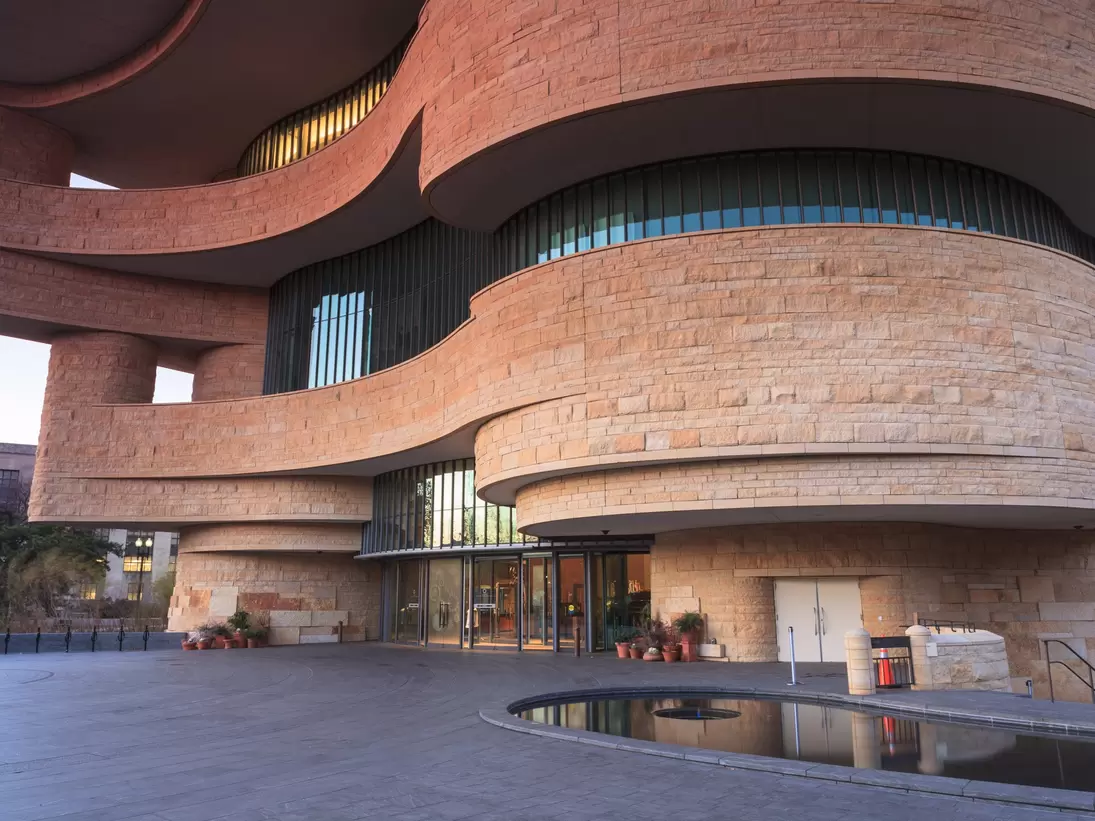 WASHINGTON, DC - NOVEMBER 30:  The entrance to the National Museum of the American Indian, as seen November 30, 2013, showcases the unusual curved architecture of the stone building.; Shutterstock ID 166031348; Your name (First / Last): Josh Vogel...